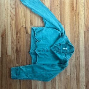 FP movement. This is a green cropped long-sleeve sweatshirt with exposed seam